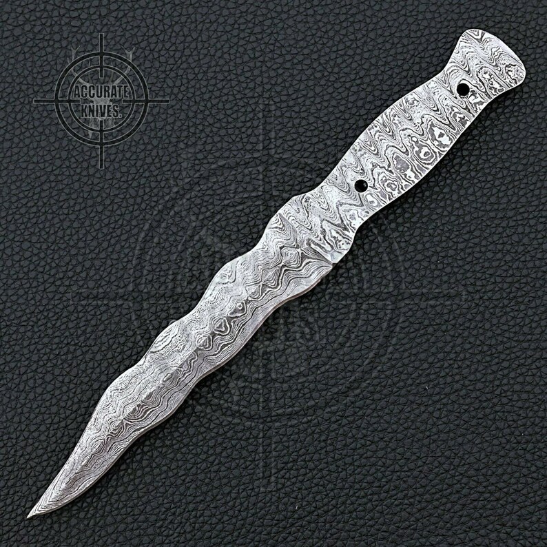 May include: A Damascus steel dagger with a wavy pattern. The blade is pointed and the handle has a textured grip with two holes. The logo "ACCURATE KNIVES" is in the upper left corner.