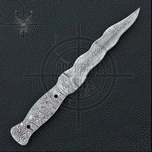 Può includere: Un pugnale in acciaio Damasco con un'impugnatura ondulata e una lama appuntita. Il coltello presenta un motivo unico ed è posto su uno sfondo scuro e strutturato. Il testo "ACCURATE KNIVES" è visibile in alto a sinistra.
