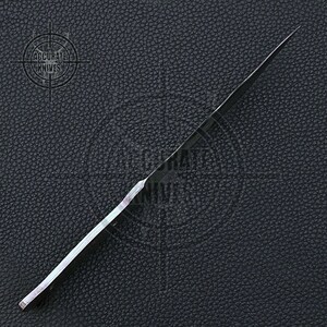 May include: A black knife with a long, slender blade. The knife is set against a dark, textured background. The text "ACCURATE KNIVES" is visible in the upper left corner.