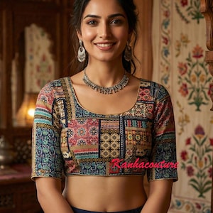 May include: A colorful patchwork crop top with short sleeves. The top features a variety of patterns in shades of blue, red, and gold. The text "Ranhacouture" is visible on the front. The top is paired with a dark blue bottom.