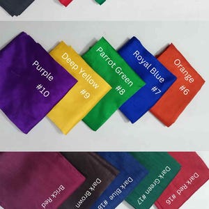 May include: A collection of folded fabric swatches in various colors, including black, red, green, blue, and magenta. Each swatch is labeled with a color name and a number.