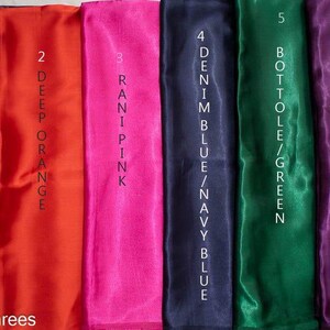 Puede incluir: Una colecci&oacute;n de seis muestras de tela en varios colores, incluyendo vino tinto oscuro, naranja intenso, rosa rani, azul denim, verde botella y ciruela. Cada muestra est&aacute; etiquetada con su nombre de color. La imagen incluye el texto "@kanhasarees".