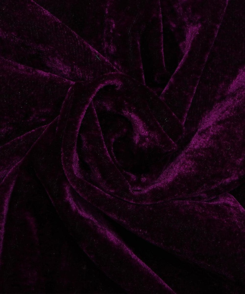 May include: Close-up of a deep purple velvet fabric with a soft, plush texture. The fabric is draped and folded, creating a luxurious and elegant look.