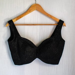 May include: A black sequined crop top with a sweetheart neckline and sleeveless straps.