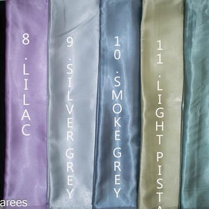 Puede incluir: Muestra vertical de muestras de tela en varios colores: negro, lila, gris plateado, gris humo, pistacho claro y sabio. Cada muestra est&aacute; etiquetada con un n&uacute;mero y el nombre del color en blanco.