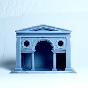 Könnte beinhalten: Ein graues 3D-gedrucktes Modell eines kleinen, klassischen Gebäudes mit einem abgerundeten Torbogen und zwei runden Fenstern. Das Gebäude hat ein flaches Dach und einen kleinen Sockel.