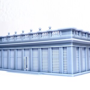 May include: A gray 3D printed model of a classical building with a balcony and a series of windows with a grid pattern.