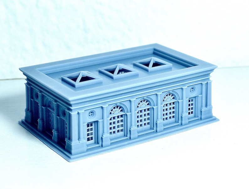 K&ouml;nnte beinhalten: Ein hellblaues Modell eines Geb&auml;udes mit einem Flachdach und drei Oberlichtern. Das Geb&auml;ude hat sechs Bogenfenster und einen dekorativen Rahmen um die Fenster und T&uuml;ren.