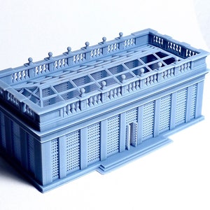 May include: A light blue 3D printed model of a small building with a detailed roof and a lattice-like facade.