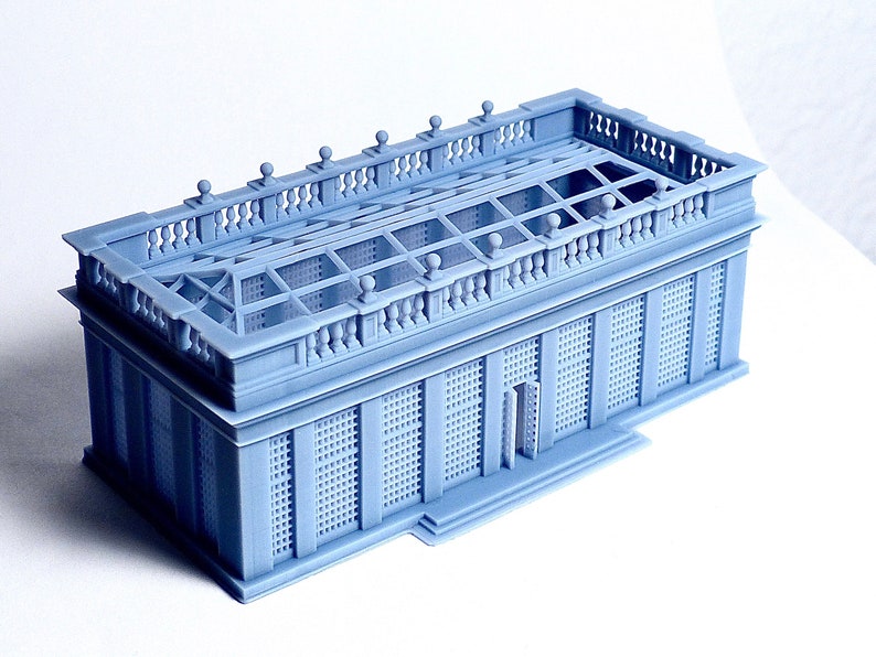 May include: A light blue 3D printed model of a small building with a detailed roof and a lattice-like facade.