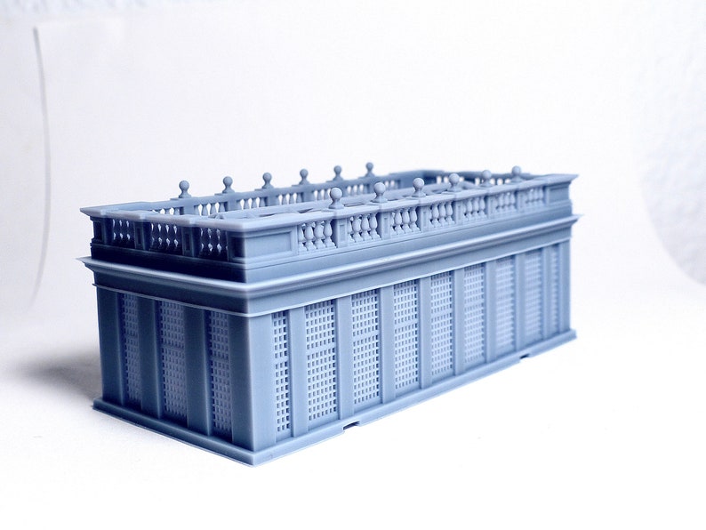 May include: A gray 3D printed model of a building with a detailed balcony and latticework facade.