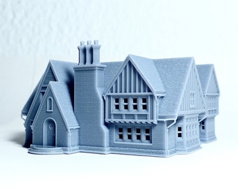 May include: A 3D printed model of a gray house with a brick chimney and a gabled roof. The house has multiple windows and a front door.