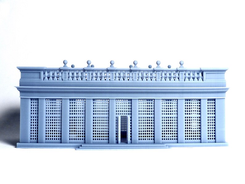 May include: A gray 3D printed model of a classical building with a balcony and a latticework facade.