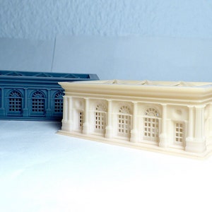 K&ouml;nnte beinhalten: Zwei 3D-gedruckte Modelle eines Geb&auml;udes im klassischen Stil. Ein Modell ist wei&szlig; und das andere grau.