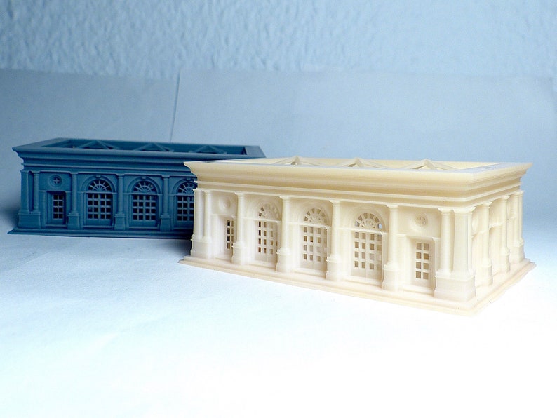 K&ouml;nnte beinhalten: Zwei 3D-gedruckte Modelle eines Geb&auml;udes im klassischen Stil. Ein Modell ist wei&szlig; und das andere grau.