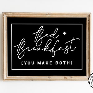 May include: Black and white sign with the text "Bed + Breakfast [You Make Both]" in a cursive font. The sign is framed in a light wood frame.