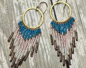 May include: Gold hoop earrings with a turquoise, white, and pink beaded fringe. The fringe is made of small beads and gold-colored metal tubes.