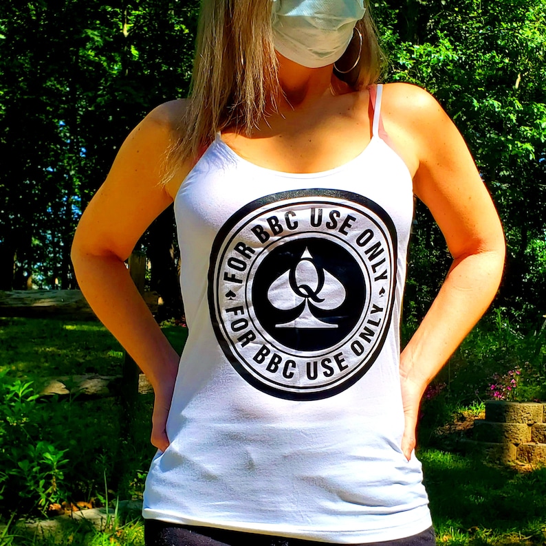 May include: White tank top with a black circle graphic that says "For BBC Use Only" with a spade symbol in the center.