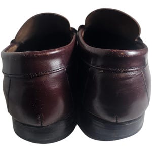 May include: A pair of brown leather loafers with a dark brown sole. The loafers have a classic design and are made of high-quality leather.