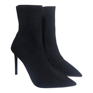 May include: A pair of black ankle boots with stiletto heels. The boots have a pointed toe and a textured fabric upper. The heels are approximately 10 cm high. The boots are set against a white background.