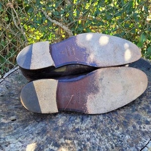 Pode incluir: Close-up das solas de um par de sapatos de couro marrom. Os sapatos t&ecirc;m uma sola de couro texturizada e uma parte superior de couro lisa.