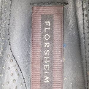 May include: Close-up of a brown leather insole with the word "FLORSHEIM" printed in white on a brown label.