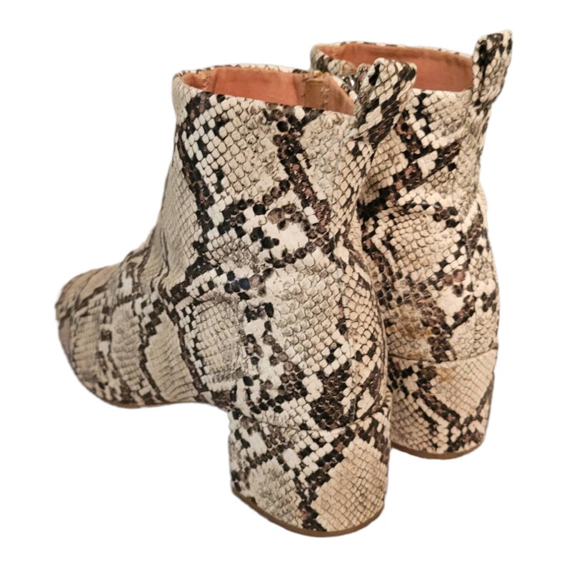 May include: A pair of ankle boots with a snakeskin pattern. The boots are a light brown color with black markings. The boots have a block heel.