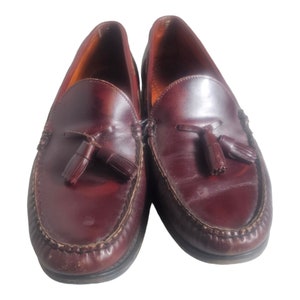 May include: A pair of dark brown leather tassel loafers. The loafers have a pointed toe and a leather sole.