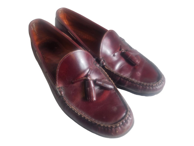 May include: A pair of brown leather tassel loafers. The loafers have a pointed toe and a tassel detail on the vamp.