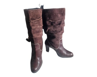 May include: A pair of brown suede boots with a slouchy design. The boots have a high heel and a pointed toe.