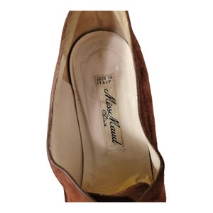 May include: Close-up of the inside of a brown suede shoe with a white label that reads "Made in Italy" and "Miss Maud Paris".