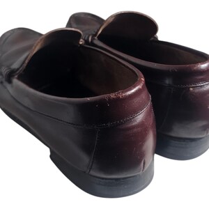 May include: A pair of brown leather loafers with a slip-on design. The loafers have a rounded toe and a low heel.