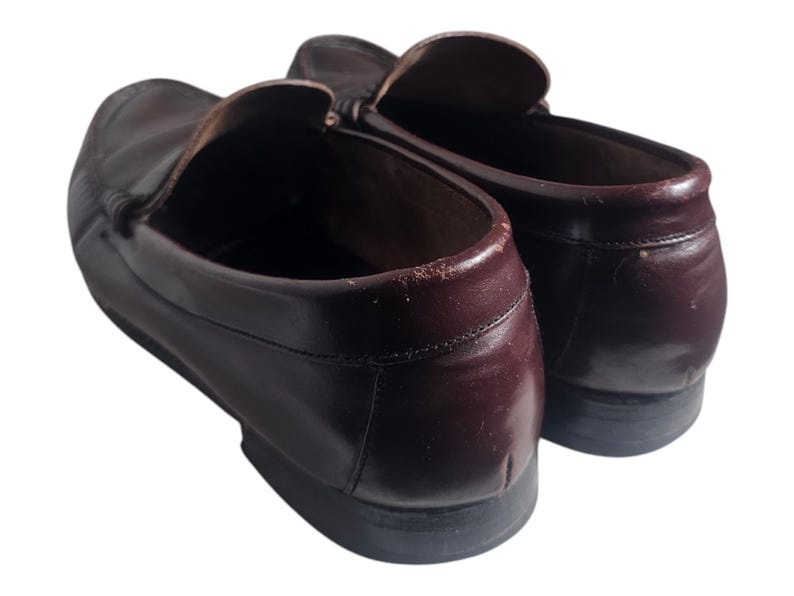 May include: A pair of brown leather loafers with a slip-on design. The loafers have a rounded toe and a low heel.