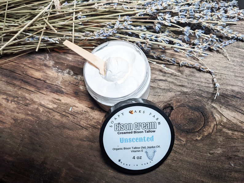 May include: A 4 ounce jar of unscented bison cream made with creamed bison tallow, jojoba oil, and vitamin E. The jar is labeled "Soapy Oaks Farm Bison Cream Creamed Bison Tallow Unscented Organic Bison Tallow (tal) Jojoba Oil Vitamin E 4 oz Made in Texas"