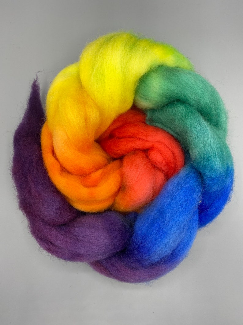 May include: A rainbow-colored ball of wool yarn, with shades of purple, blue, orange, red, green, and yellow.