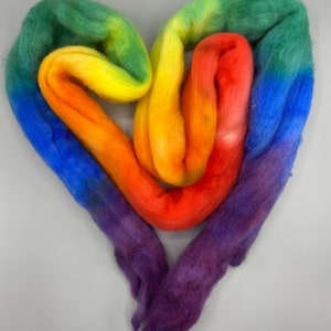 May include: A heart-shaped arrangement of colorful wool roving in shades of purple, blue, green, yellow, orange, and red.