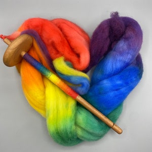 May include: Rainbow colored wool roving arranged in a heart shape with a wooden spinning wheel spindle.