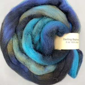 May include: A 2 oz. skein of hand-dyed wool yarn in shades of blue, teal, and black. The yarn is called "Darling Baphomes" and is 100% wool.