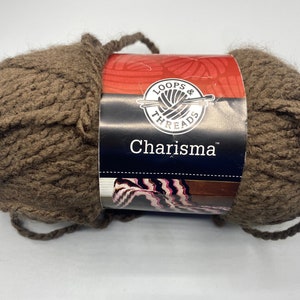 May include: A brown ball of yarn labeled "Loops & Threads Charisma" with a close-up of the label showing a ball of yarn with knitting needles.