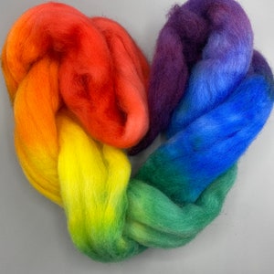 May include: Rainbow colored wool roving arranged in a heart shape. The colors are red, orange, yellow, green, blue, and purple.