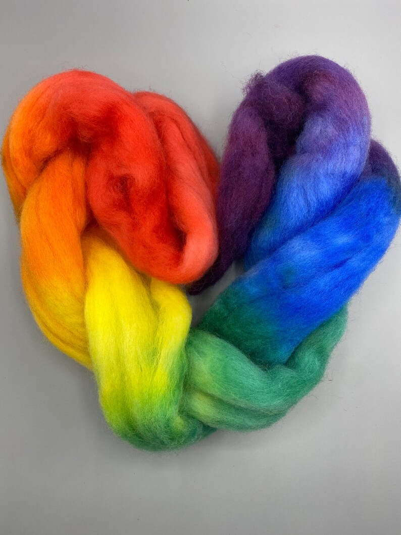 May include: Rainbow colored wool roving arranged in a heart shape. The colors are red, orange, yellow, green, blue, and purple.