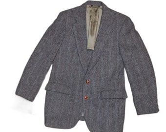May include: A gray tweed blazer with two brown buttons and two front pockets. The blazer has a notched lapel and a light green lining. The jacket is a classic style, suitable for various occasions.
