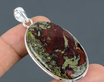 May include: A silver pendant featuring a large oval-shaped green and red jasper stone. The stone has a unique pattern of swirling colors and textures.