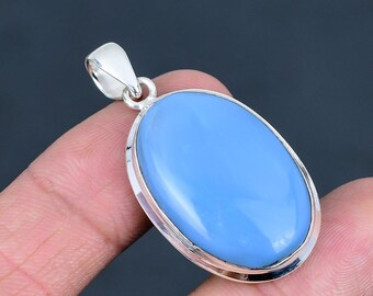 May include: Oval-shaped pendant with a light blue gemstone set in a silver-colored metal frame. The pendant has a bail for attaching to a chain. The gemstone has a smooth, polished surface and a soft, pastel color.