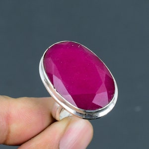 Op de afbeelding: Een zilveren ring met een grote, ovale, gefacetteerde, roze edelsteen.