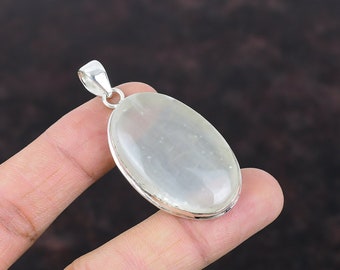 May include: A silver pendant with a white oval moonstone gemstone.