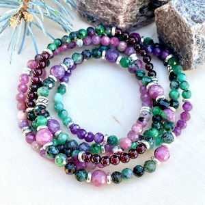 May include: Multi-strand bracelet featuring green, pink, and purple gemstone beads with silver accents.