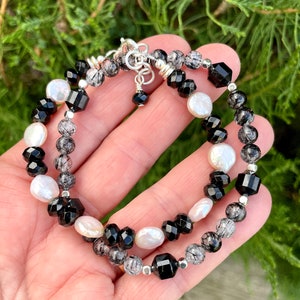Peut inclure: Un bracelet compos&eacute; de perles d'onyx noir, de perles blanches et de quartz clair. Le bracelet est fait de m&eacute;tal argent&eacute;.