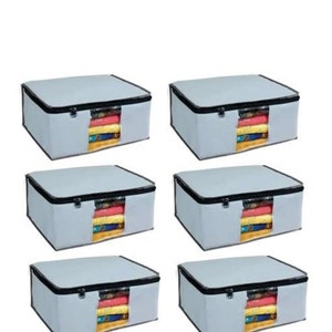 May include: Six grey storage boxes with black zips and trim. Each box has a clear window displaying folded clothes in various colours. The boxes are rectangular with a flat top.