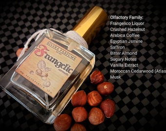 May include: A clear glass bottle with a gold cap and a label that reads "RIVERA PARFUMS EST. 2012 Frangelic aromatic" and "RAUDEPARFUM 10 ml". The bottle is surrounded by hazelnuts. The text "Olfactory Family: Frangelico Liquor Crushed Hazelnut Arabica Coffee Egyptian Jsmine Saffron Bitter Almond Sugary Notes Vanilla Extract Moroccan Cedarwood (Atlas) Musk" is visible on the right side of the image.